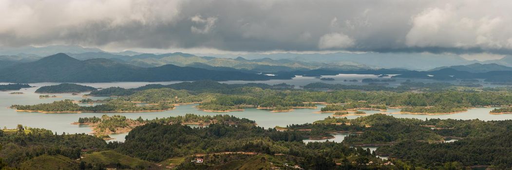 View at the top of El Penon de Guatape looking out at layers of beautiful land water and terrain. Panoramic view