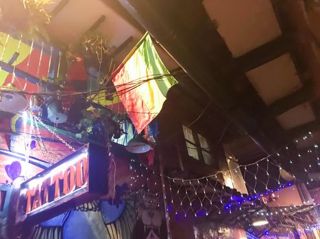 Tattoo shop in Bogota with Colombian flag and decorative lights.