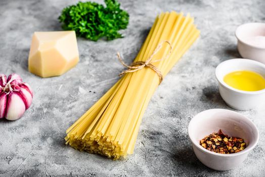 Raw ingredients for cooking linguine with olive oil, garlic and parsley