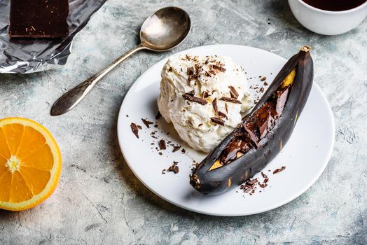 Sweet dessert. Grilled banana with dark chocolate, citrus juice and vanilla ice cream.