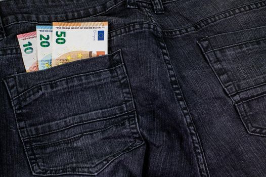 10 20 50 euros that come out of the pocket of black jeans