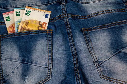 10 20 50 euros that come out of the pocket of blue jeans