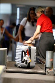salvador, bahia, brazil - july 27, 2018: an airline attendant weighs a suitcase on a conveyor belt at check-in at the airport in the city of Salvador.