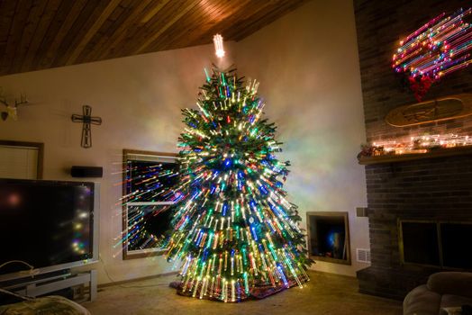 Large decorated Christmas tree inside of living room with light streaks