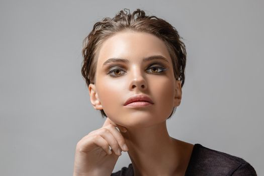 Woman makeup face fashion beautiful portrait short hairstyle slicked. Portrait on a neutral background in the studio.