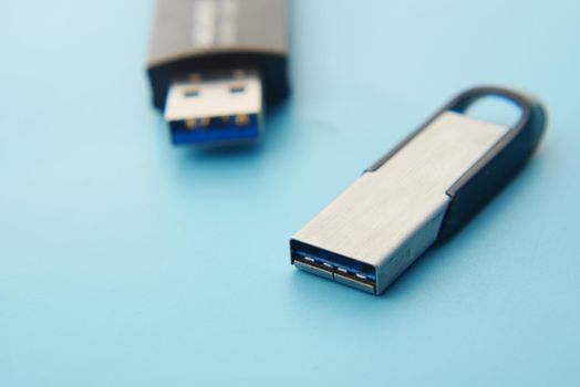 USB flash drive on blue background close up .