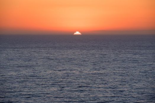 California sunset over the ocean horizon with bright orange sky Los Angeles