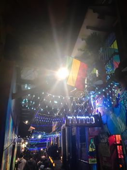 Night life in Bogota with Colombian flag, Christmas lights, and tourists.