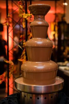 Chocolate fountain with layers. Vertical crop