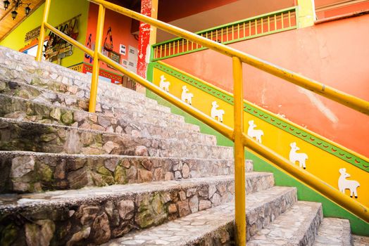 View of downtown Guatape, Colombia with cobblestone staircase and colorful llama pattern.