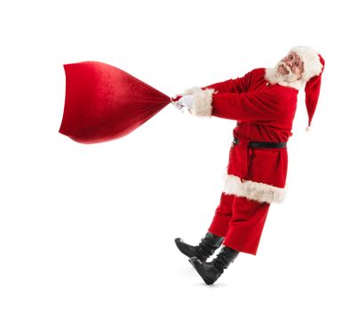 Santa Claus with a big bag on isolated white background. Funny Santa throw large sack of Christmas gifts. Cheerful Santa Claus spin bag with gifts.