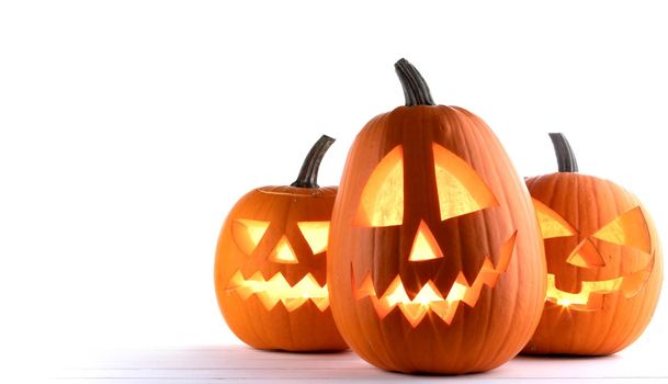 Three glowing Halloween Pumpkin lanterns isolated on white background