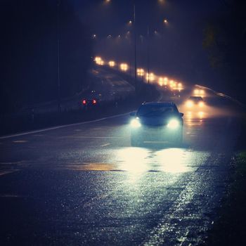 Car on the road in the fog. Autumn landscape - dangerous road traffic in winter season.