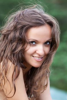 Portrait of emotional half-naked young woman on natural background