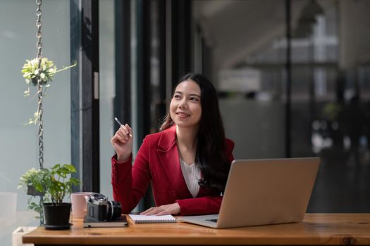 Portrait of attractive young asian woman working with laptop computer.