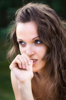 Portrait of emotional half-naked young woman on natural background