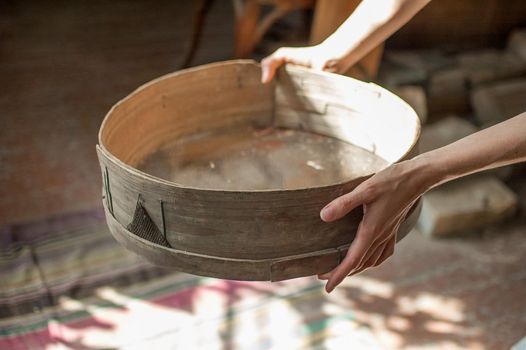 Old sieves from history museum, tool for bakery from the past for flour sifting in female hands.