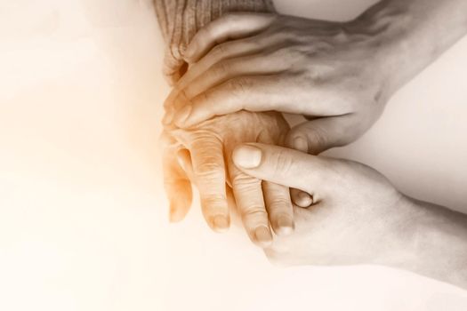 Handshake, caring, trust, treatment and support. The hand of a young doctor holds the hand of an elderly woman, or he checks the comma to see how the bones have grown together. Medicine and healthcare