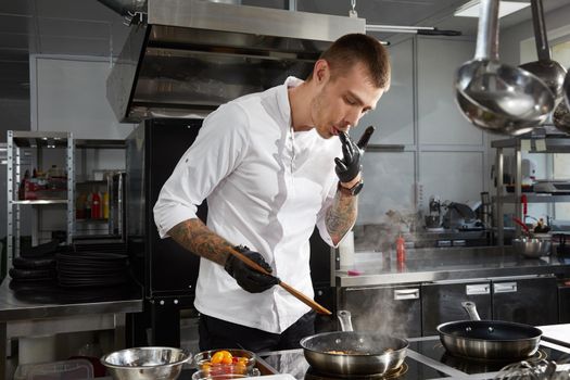 Professional chef cooking in the kitchen in hotel restaurant, preparing salad with shrimps