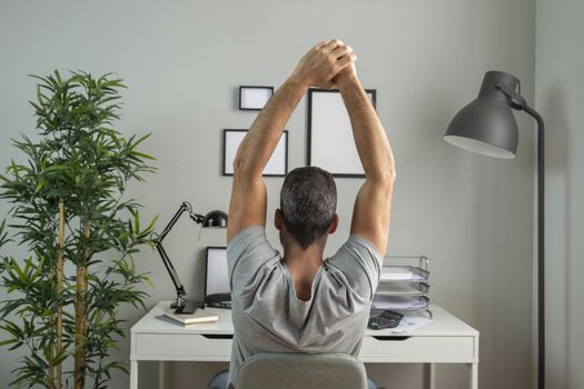 back view man desk stretching while working from home. Resolution and high quality beautiful photo