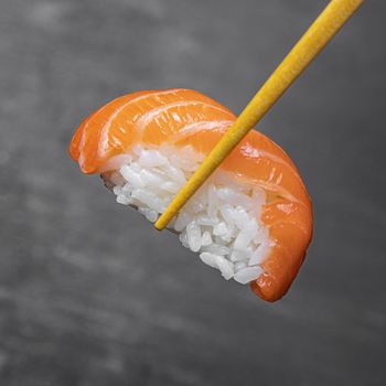 close up sticks holding tasty sushi 2. Resolution and high quality beautiful photo