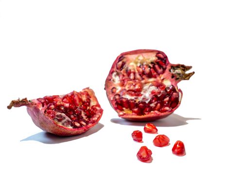 Pomegranate on white background. Fruits. Minimalism. White. Red. Useful product. Ripe. Fruit iridescent in the light.
