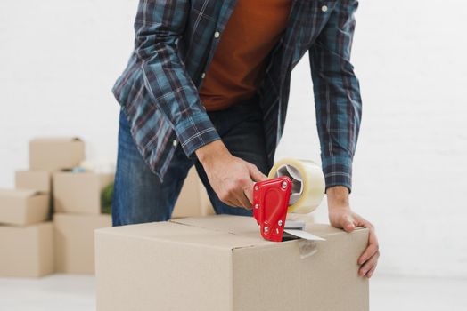 close up man sealing cardboard box with duct tape. Resolution and high quality beautiful photo