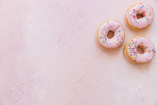 overhead view fresh donuts with sprinkles pink backdrop. Resolution and high quality beautiful photo