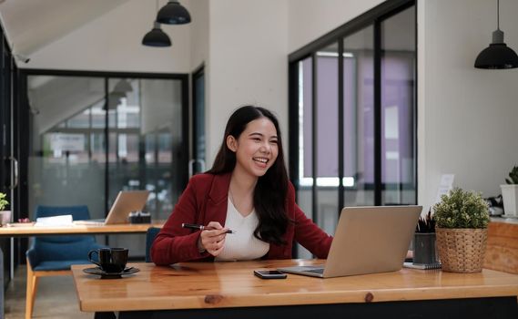Enjoy moment, Shot of young asian woman working with laptop computer for business financial at a coffee shop with a laptop.