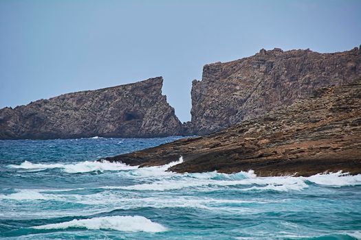 Cliff on the coast in the shape of a letter v. Mediterranean Sea, Balearic Islands, turquoise water, moving water