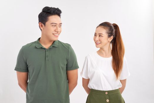 Photo of happy boyfriend and girlfriend smiling and looking on each other isolated over white background