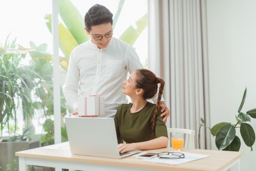 Young asian men presenting gift to glad girl