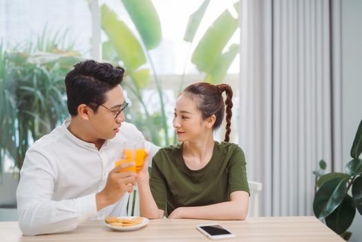 Happy young asian couple making organic drink together. 