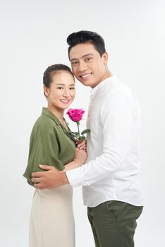 Young man giving rose to his girlfriend on white background