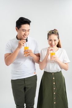 love, family, healthy food and happiness concept - smiling happy couple drinking juice on white background