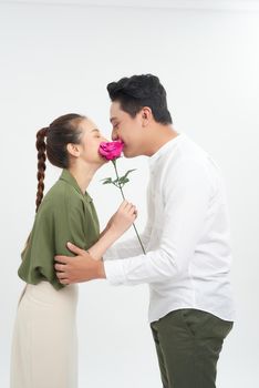 Beautiful elegant couple is kissing behind roses