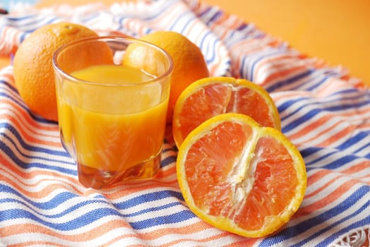 orange juice in glass on a color background .
