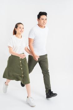 Young couple in casual clothes walking on white background