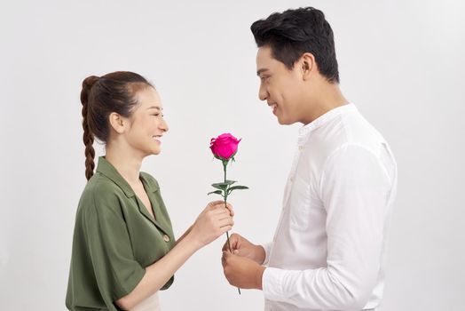 romantic moment: young man giving a rose to his girlfriend