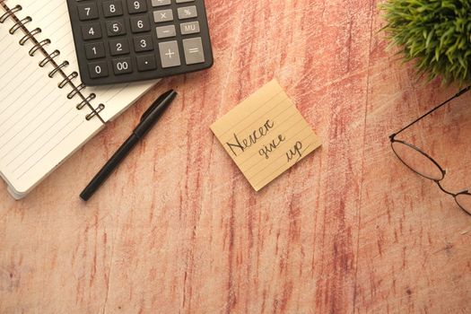 never give up word on stick note on table