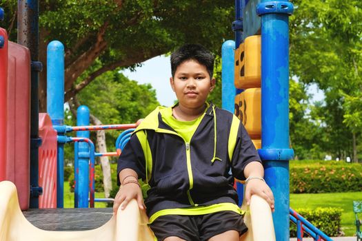 Sport and lifestyle Concept: Young asian boy sitting on playground at outdoor playground