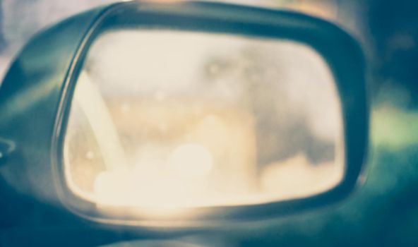 Vintage Style - blurred luxury car on road with side mirror.