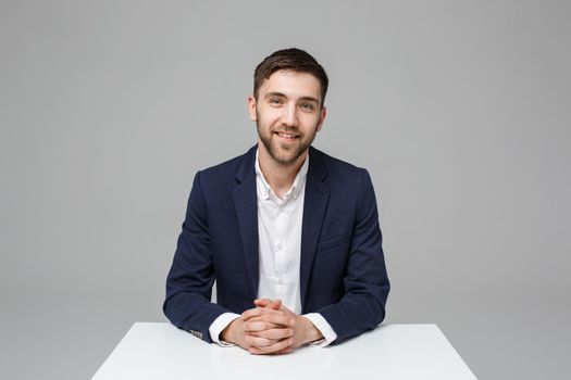 Business Concept - Portrait handsome happy handsome business man in suit smiling and siting in work office. White Background.