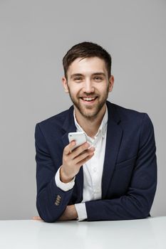 Business Concept - Portrait handsome happy handsome business man in suit playing moblie phone and smiling with laptop at work office. White Background.