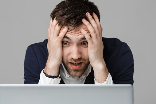 Business Concept - Portrait handsome stressful business man in suit shock looking at work in laptop. White Background.