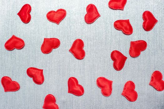red hearts scattered on a silver background