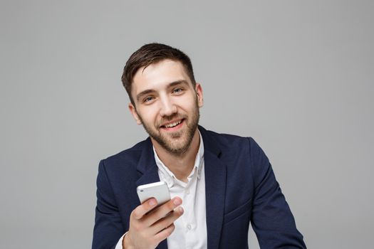 Business Concept - Portrait handsome happy handsome business man in suit playing moblie phone and smiling with laptop at work office. White Background.