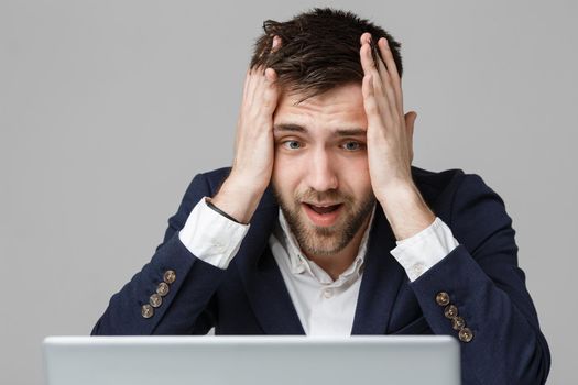 Business Concept - Portrait handsome stressful business man in suit shock looking at work in laptop. White Background.