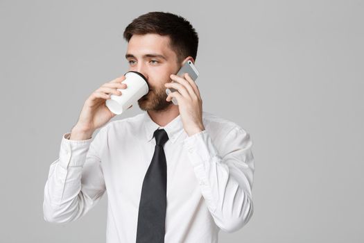 Business Concept - Portrait of a handsome businessman in eyeglasses with a cup of coffee and smartphone.