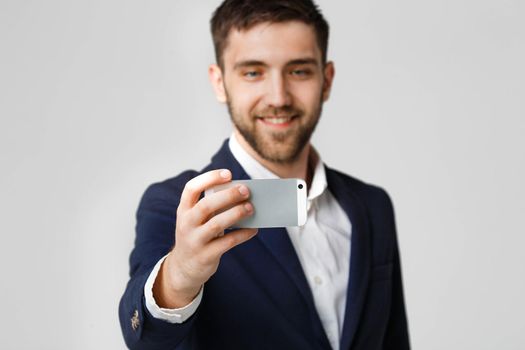 Business Concept - Handsome Business man take a selfie of himself with smartphone. White Background.